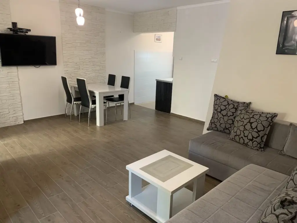 Modern living-dining room with gray sofa and white table