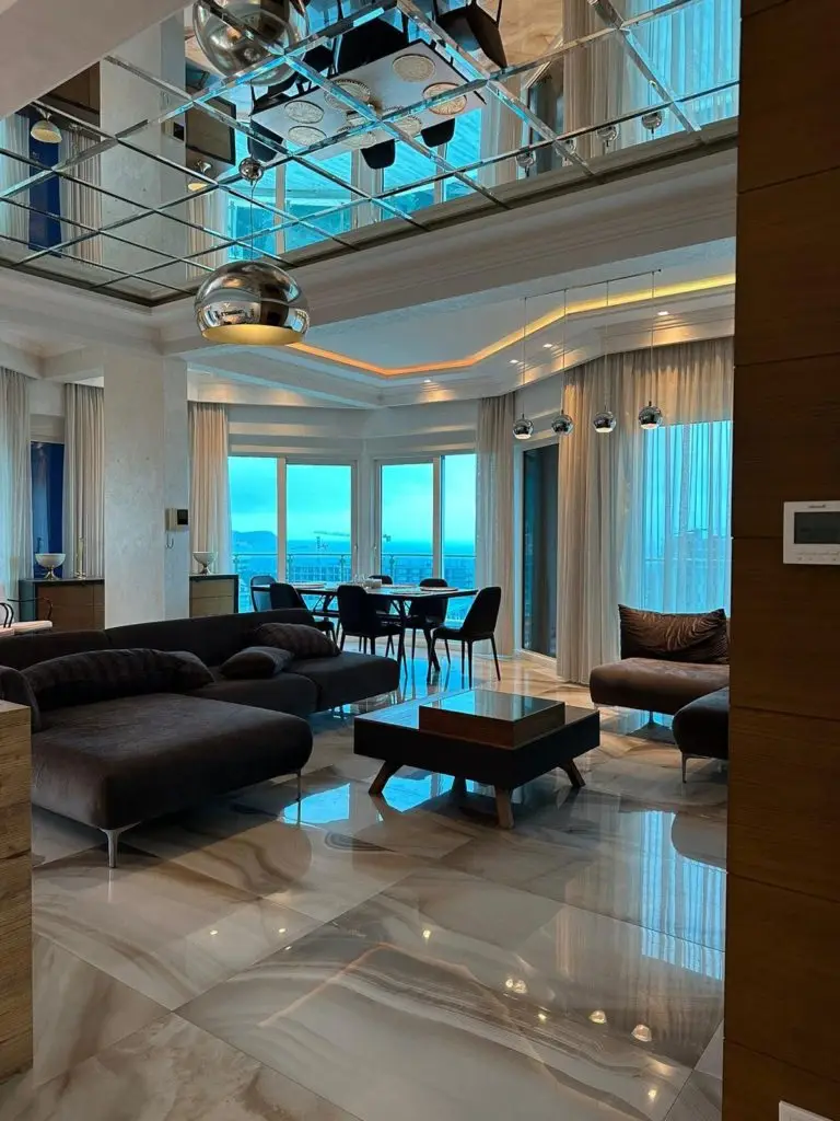 Luxury living room with ocean view, sofa, dining table, mirrored ceiling