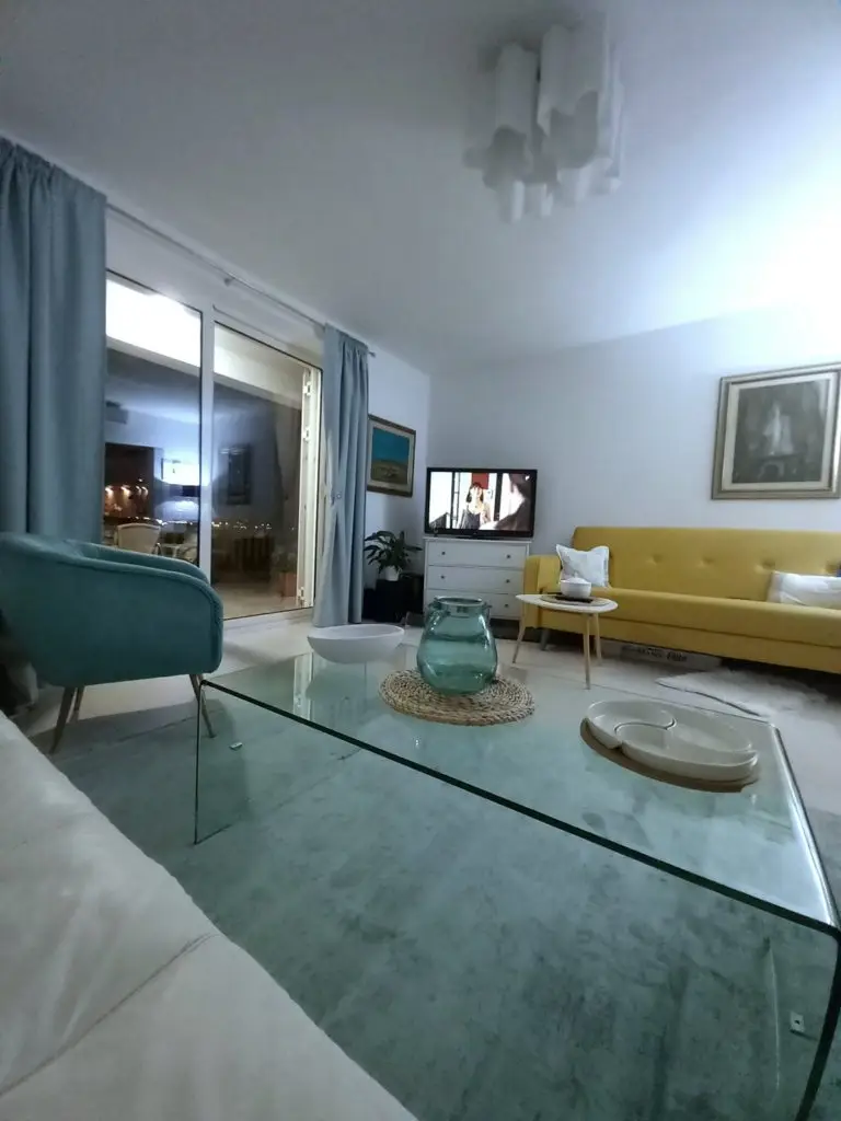 Modern living room with yellow sofa and glass coffee table