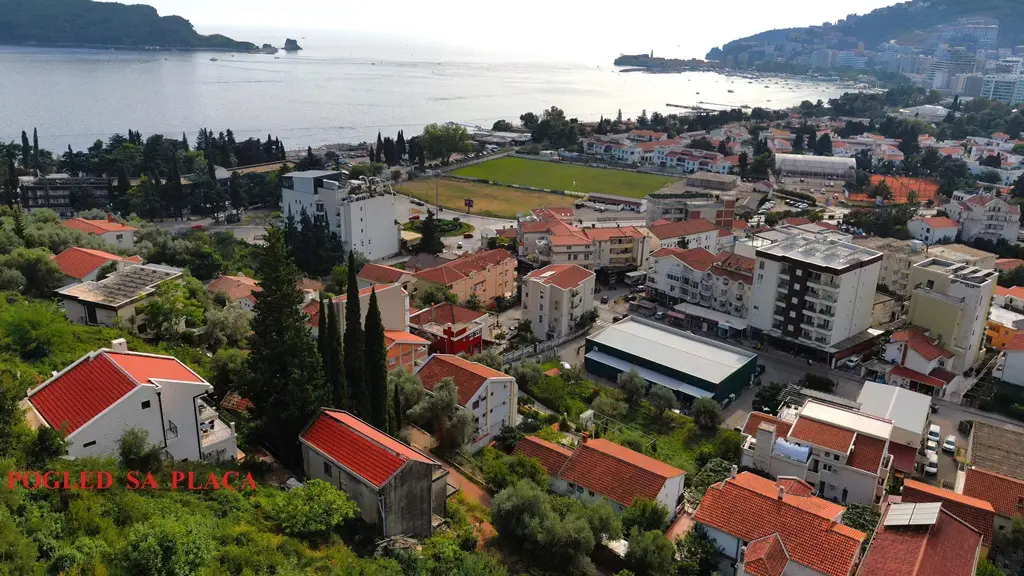 Coastal town with sea, red-roof houses, and buildings