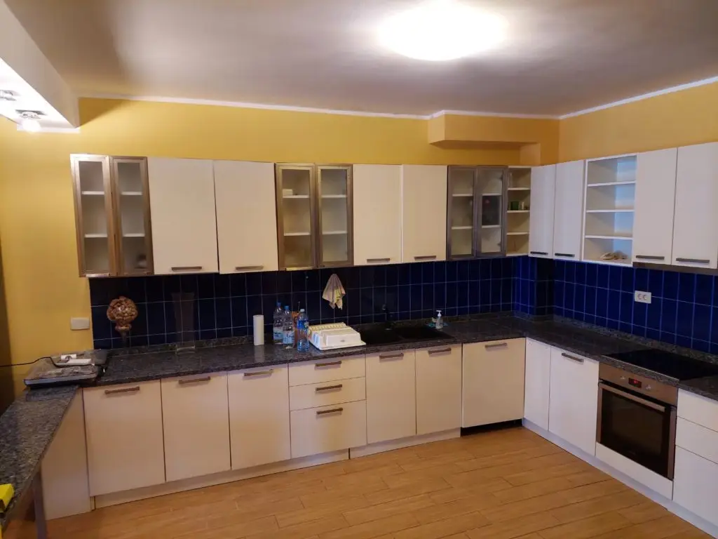 Modern kitchen with beige cabinets and blue tile backsplash
