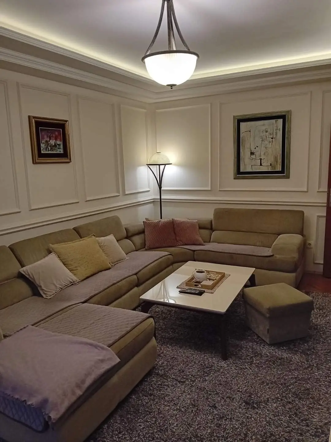 Beige sectional sofa, coffee table, and floor lamp in living room