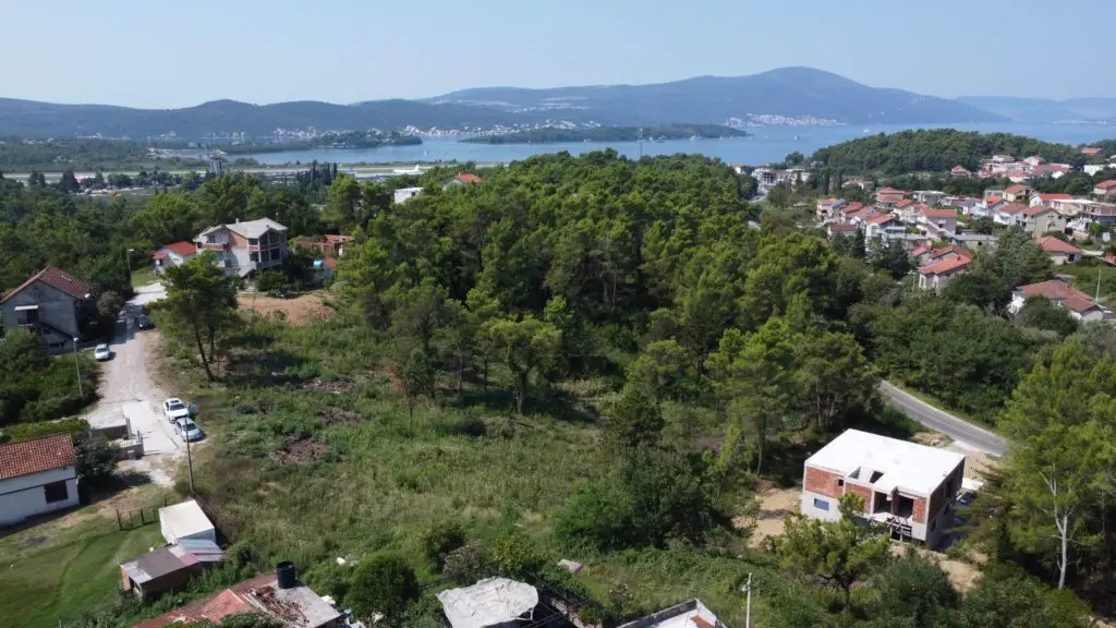 Vacant wooded lot above houses overlooking the bay and mountains