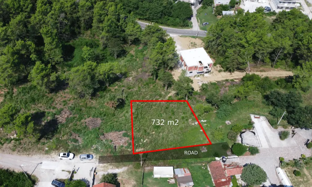 Aerial view of a 732 m2 plot outlined in red beside a road