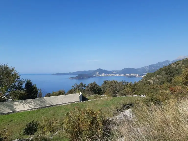 Grassy hillside plot overlooking the sea and distant coastline