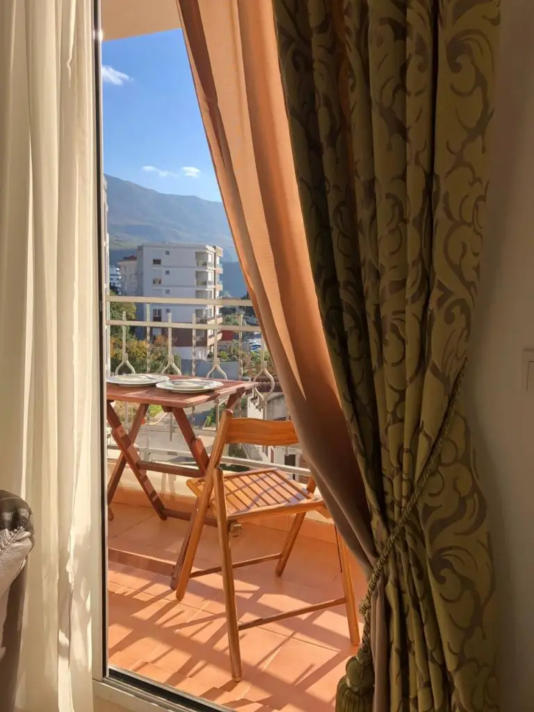 Balcony with wooden table, chair, and mountain view