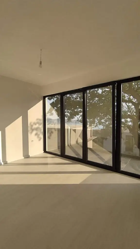 Empty room with floor-to-ceiling windows and sea view