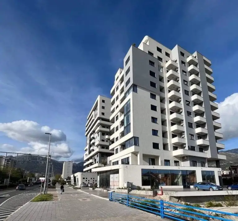 Modern white apartment building with balconies on a street