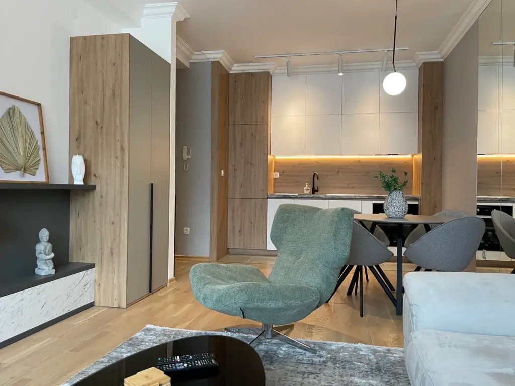Modern open-plan living room and kitchen with green chair