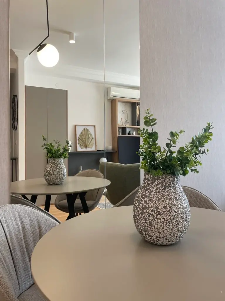 Modern dining area with round table, chairs, and vases