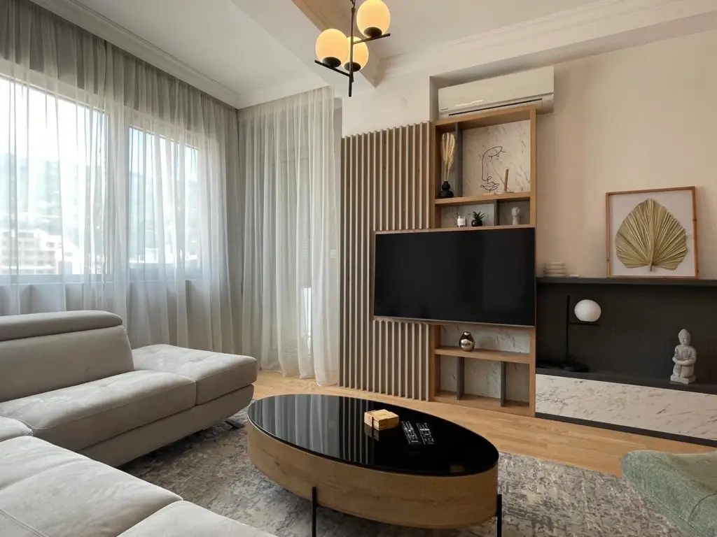 Modern living room with gray sectional, TV wall, and oval coffee table
