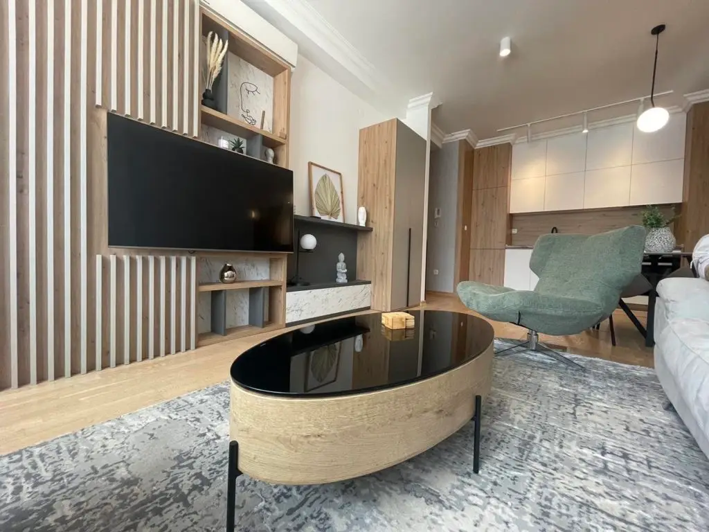Modern living room with wall-mounted TV and oval coffee table