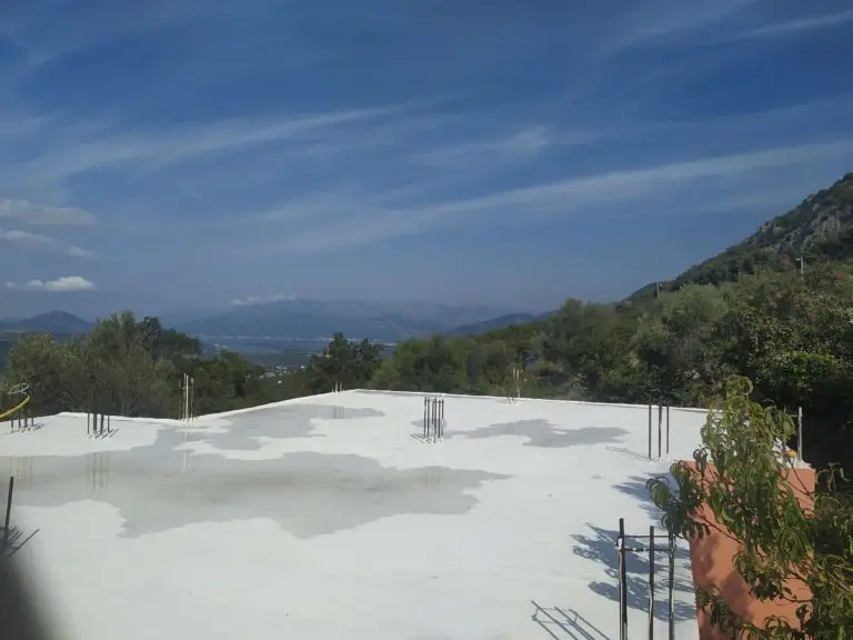 Concrete foundation slab with exposed rebar and mountains beyond