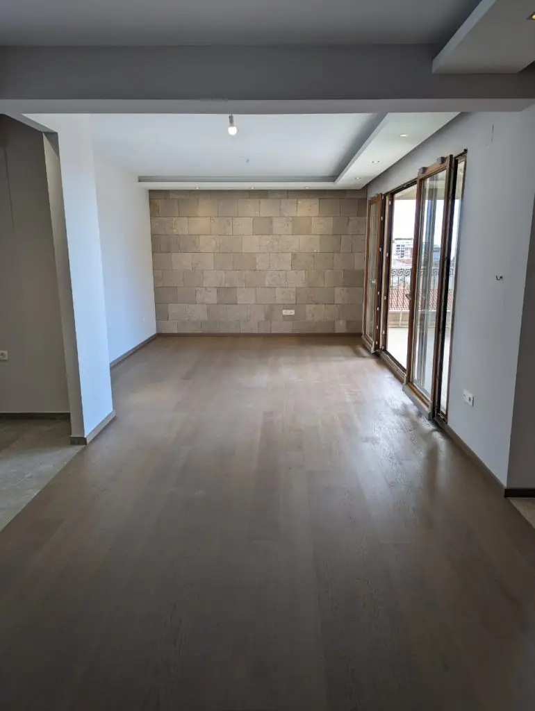 Empty modern living room with wood floor and balcony doors