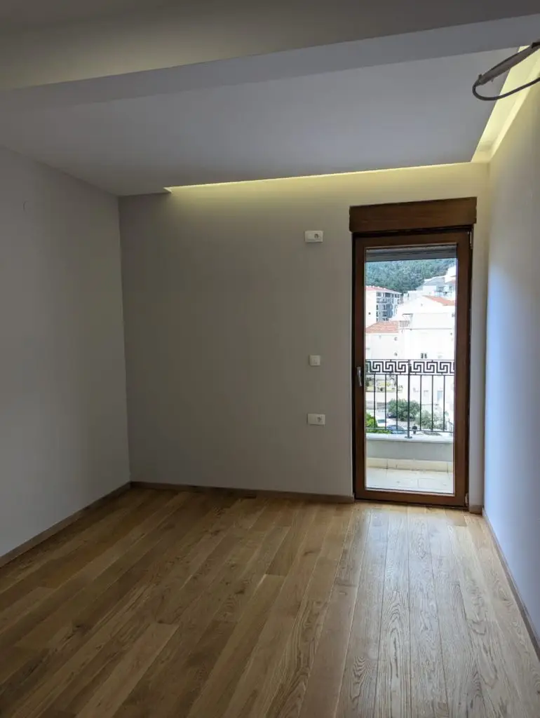 Empty room with wood floor and glass balcony door