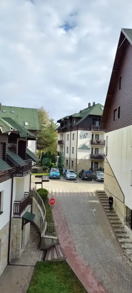 Courtyard between apartment buildings with parked cars and a stop sign