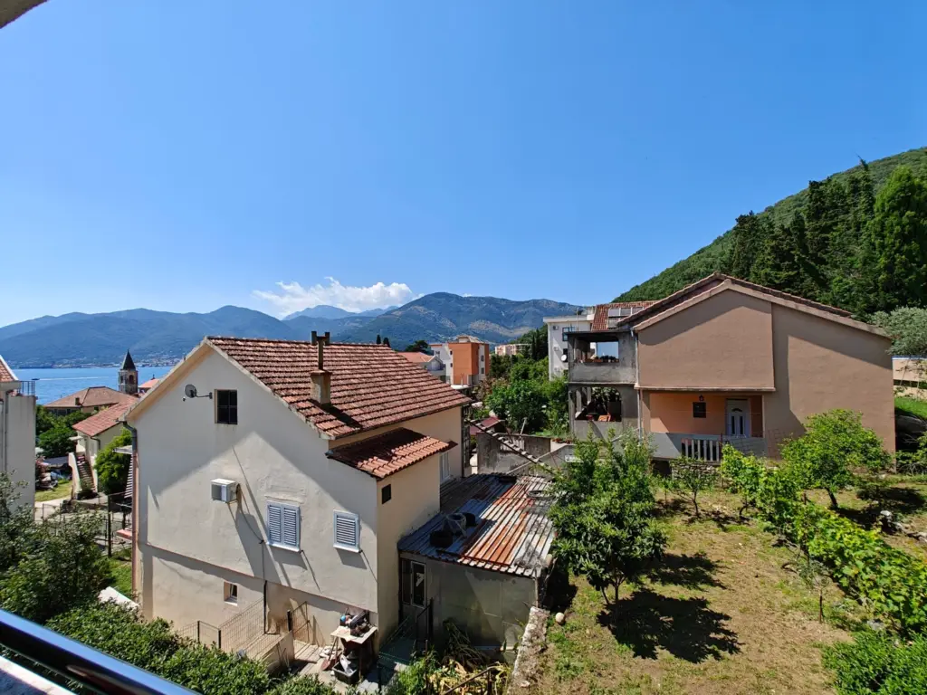 Houses with red roofs overlooking the bay and mountains