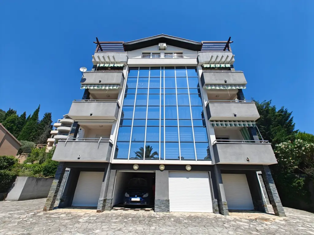 Modern gray apartment building with glass facade and balconies