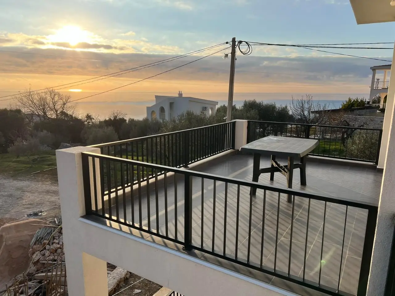 Balcony terrace with table overlooking sea at sunset