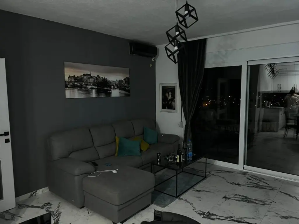 Modern gray living room with sectional sofa and glass coffee table