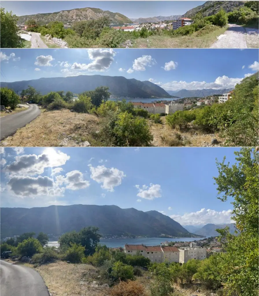 Hillside road overlooking bay, mountains, and town buildings