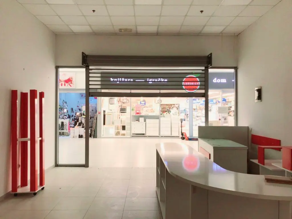 Empty retail space facing a bookstore and toys shop storefront