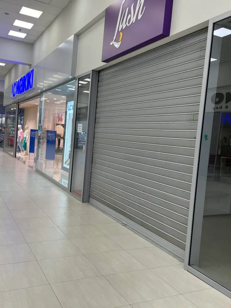 LC Waikiki storefront beside a closed metal shutter