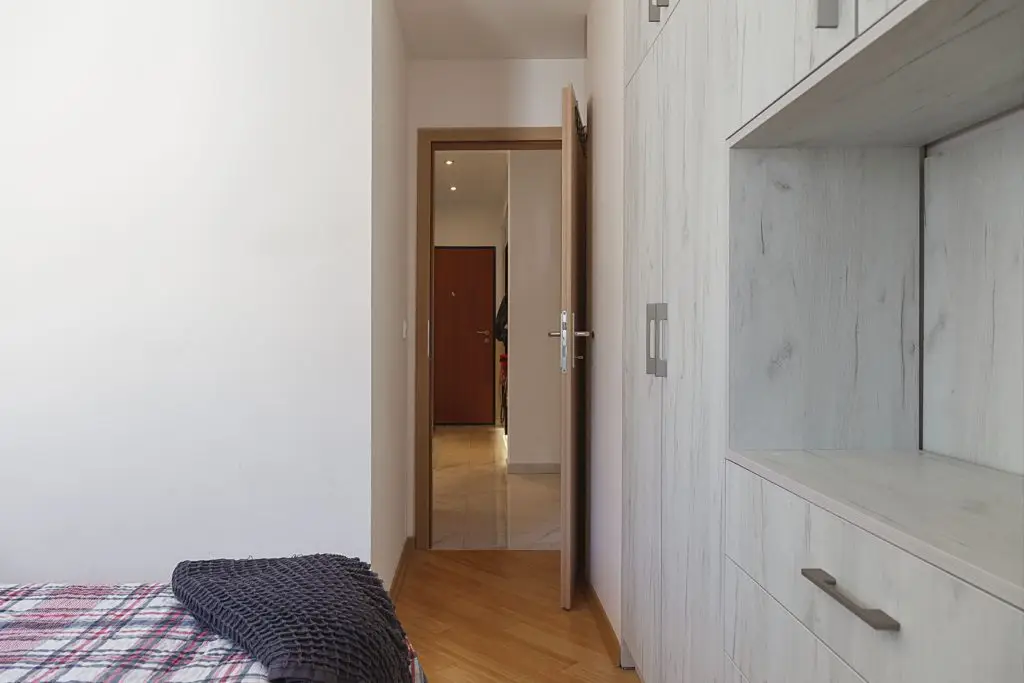 Bedroom corner with open door and built-in wardrobe