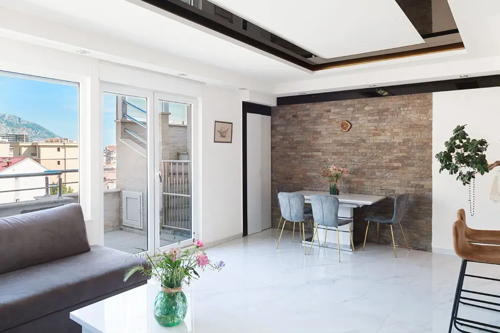 Bright modern living room with dining table and balcony view