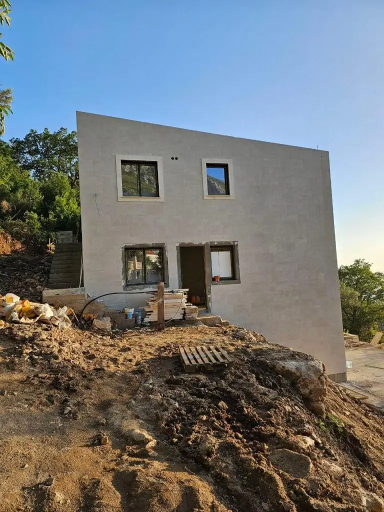 White house under construction on rocky hillside