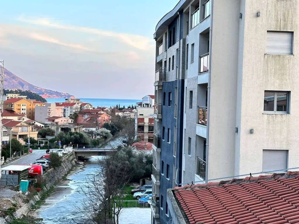 Residential buildings beside a canal with sea in distance