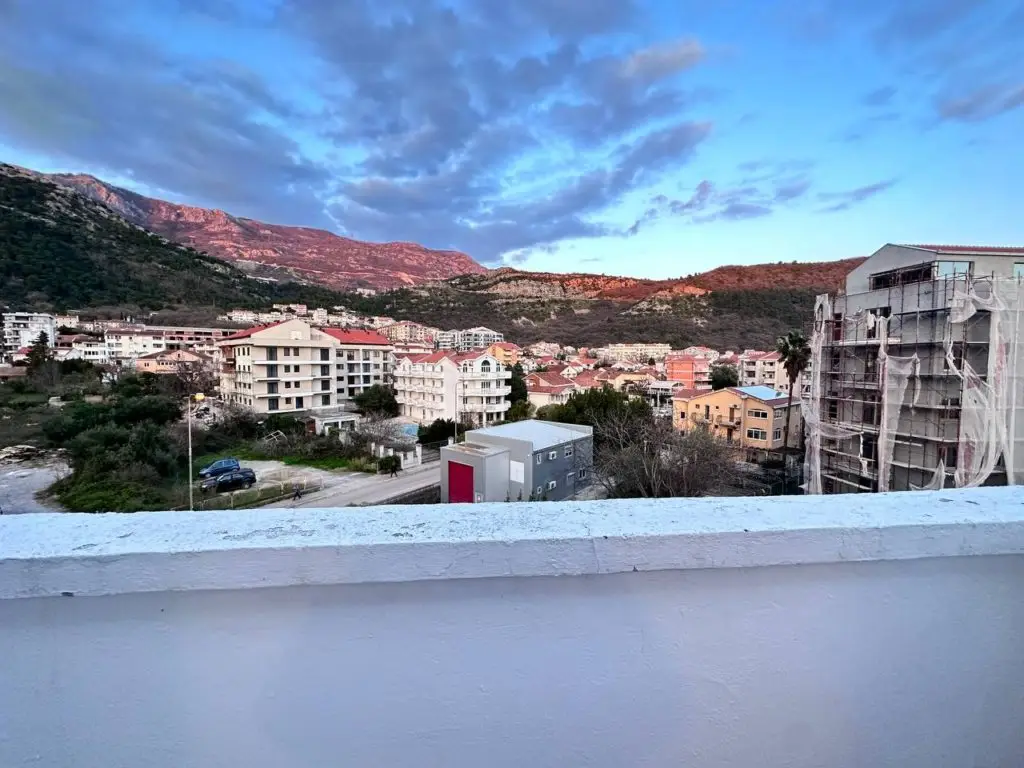 View of buildings and mountains from a balcony