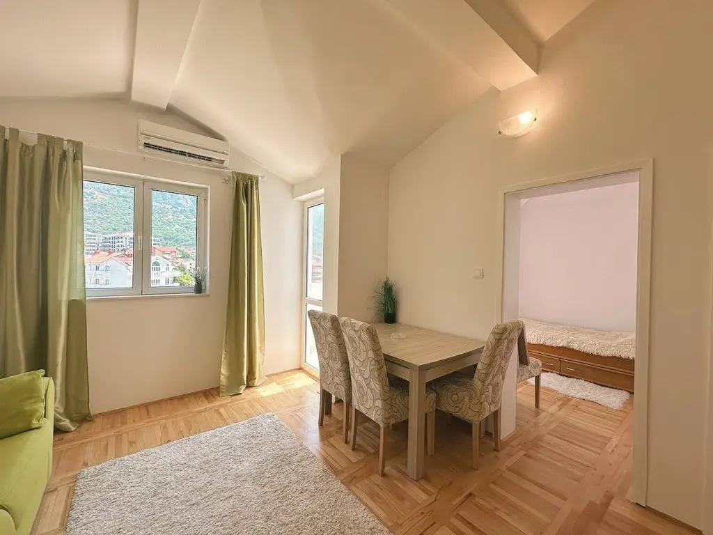 Living and dining room with green curtains and bedroom doorway