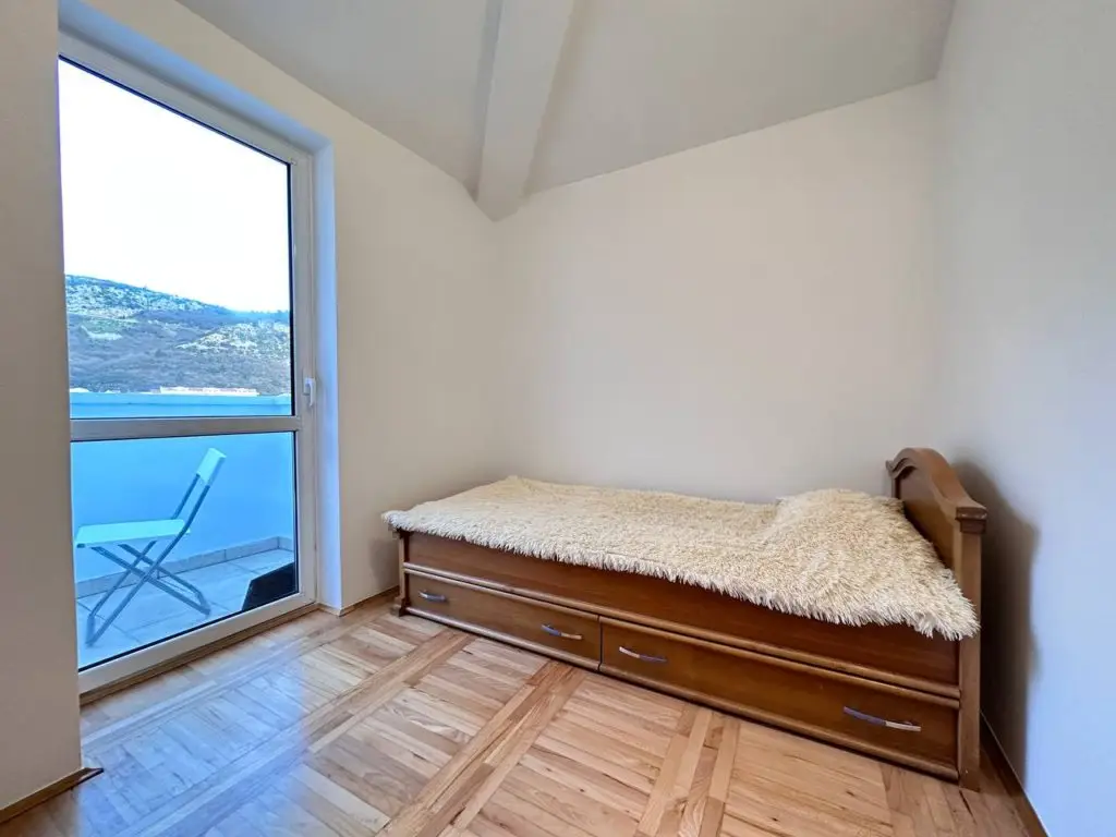 Small bedroom with single bed and balcony view