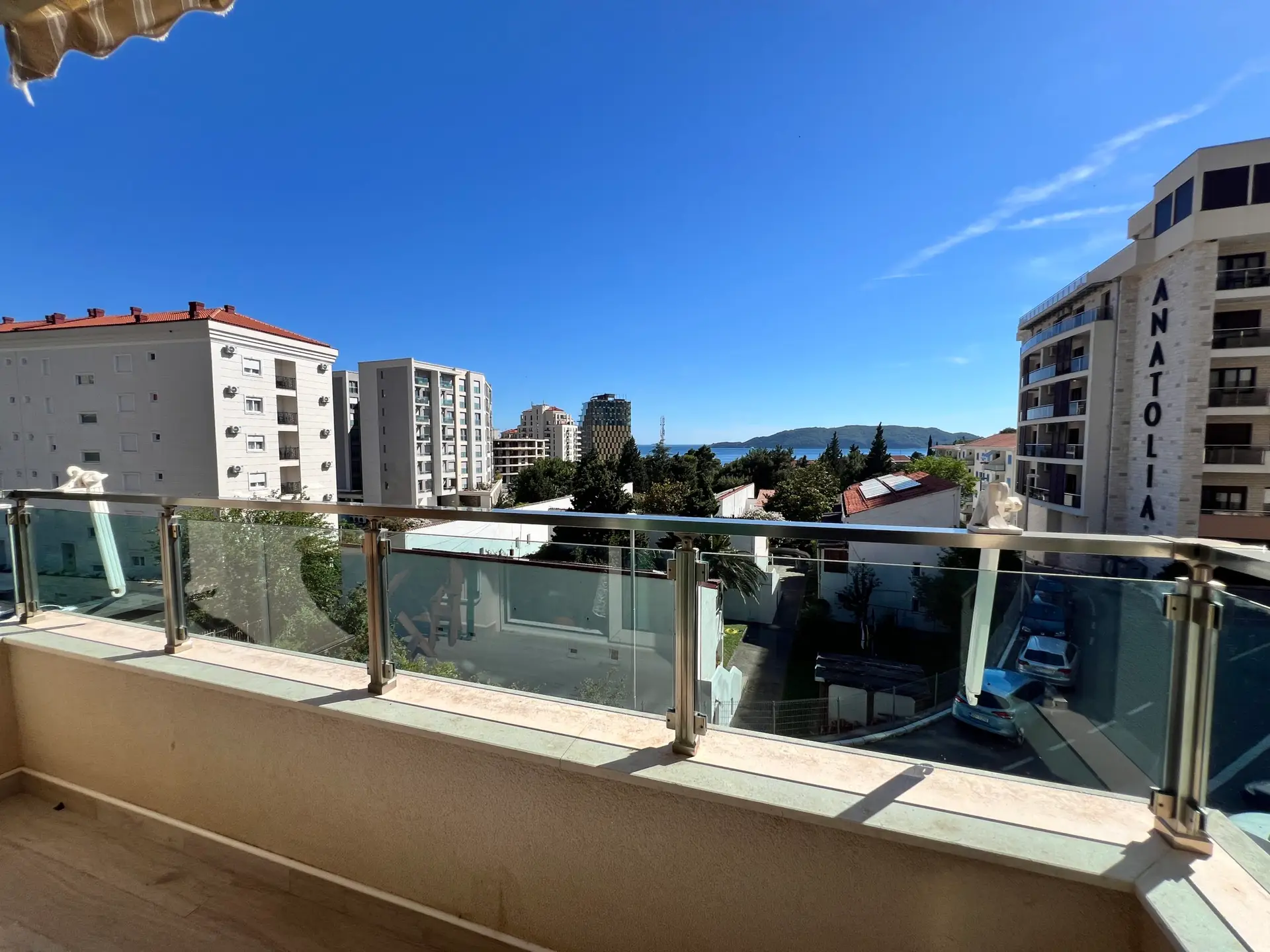 Balcony view over buildings toward the sea, with ANATOLIA tower