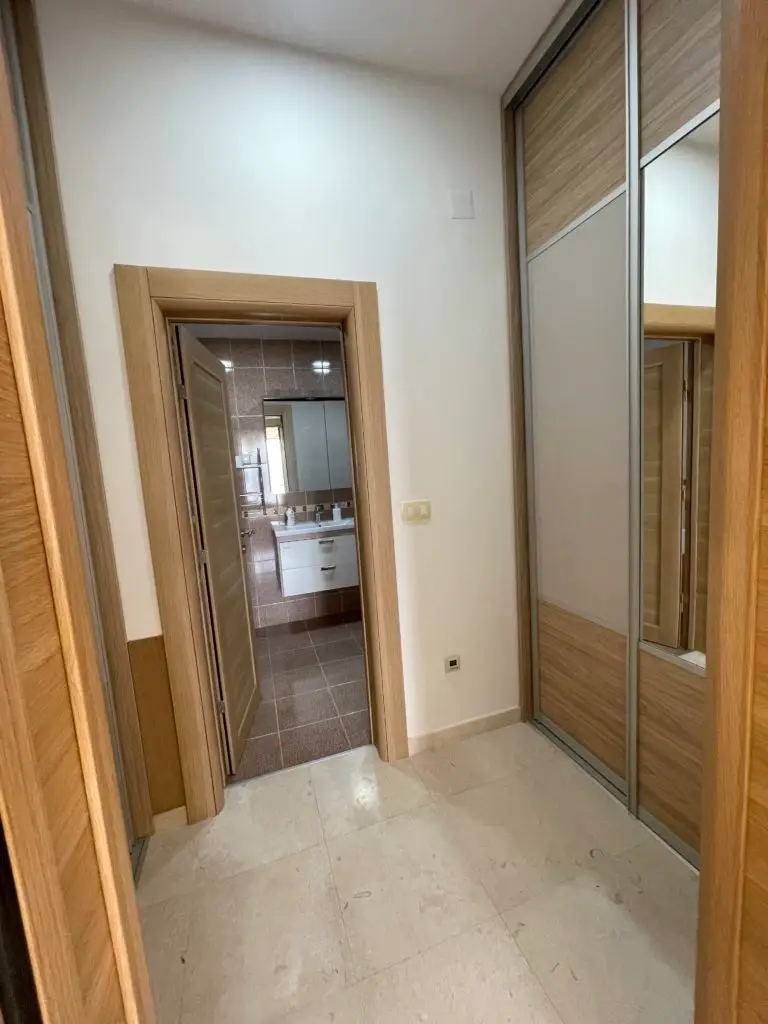 Hallway with mirrored wardrobe and open bathroom doorway