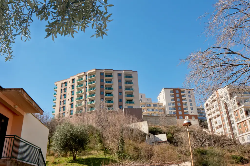 Apartment buildings on a hillside under a clear blue sky