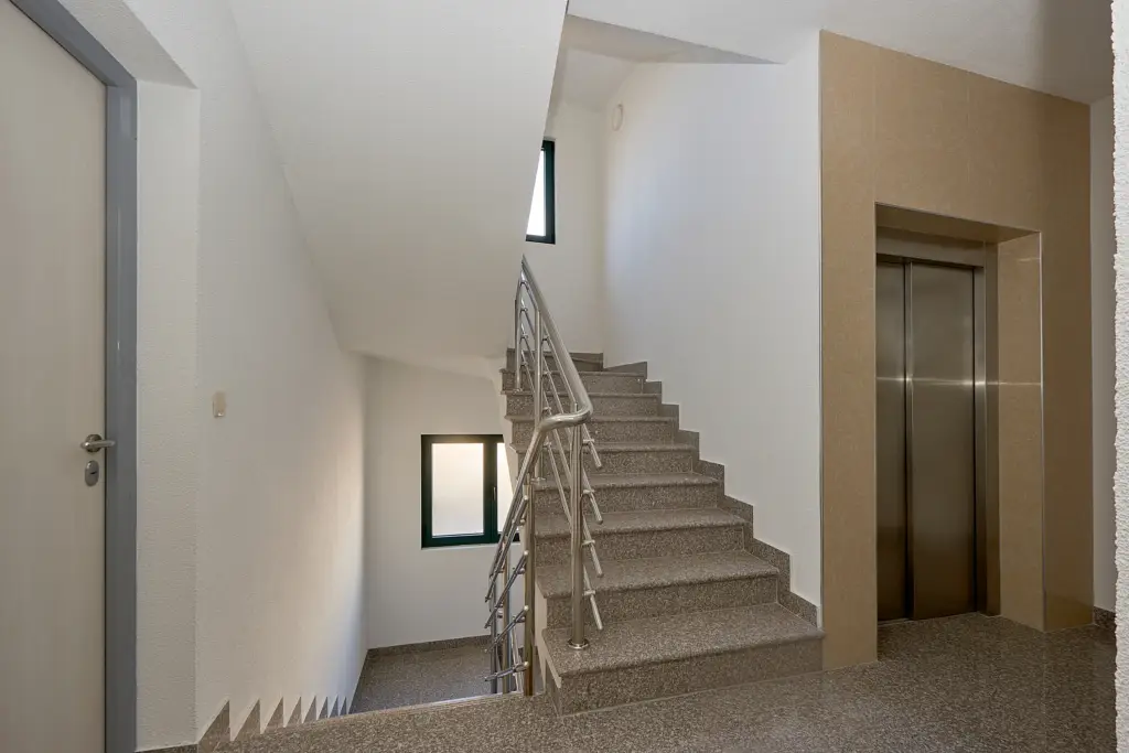 Stairwell with granite steps and an elevator door