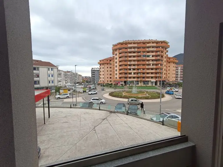 View of roundabout with fountain and apartment buildings from balcony window