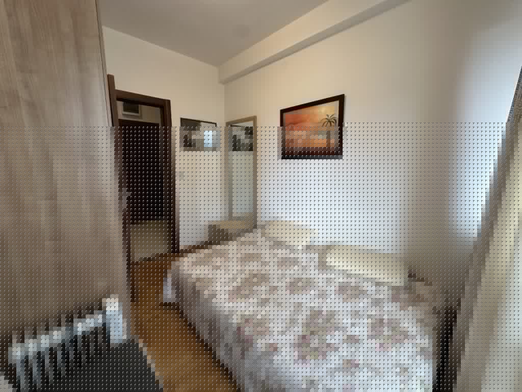 Small bedroom with floral bedspread, wardrobe, mirror, and wall art