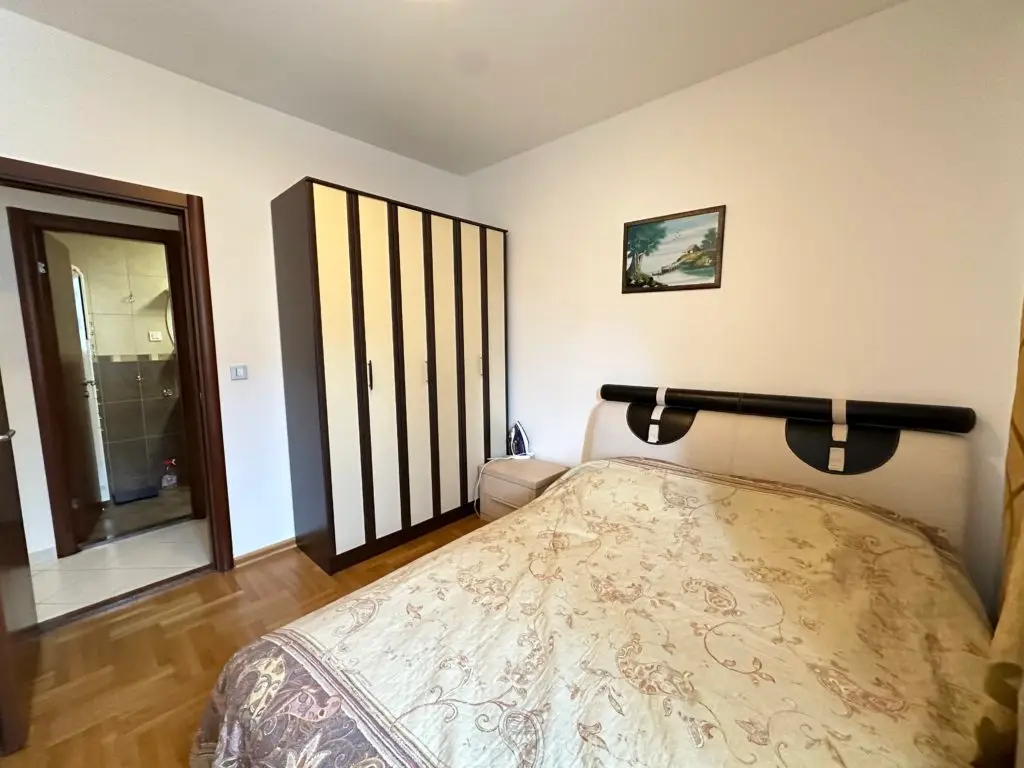 Bedroom with bed, wardrobe, and bathroom doorway