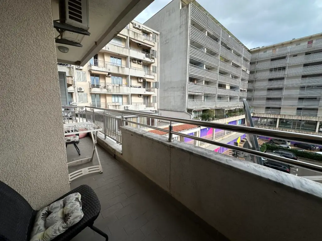 Apartment balcony overlooking neighboring buildings and parking area