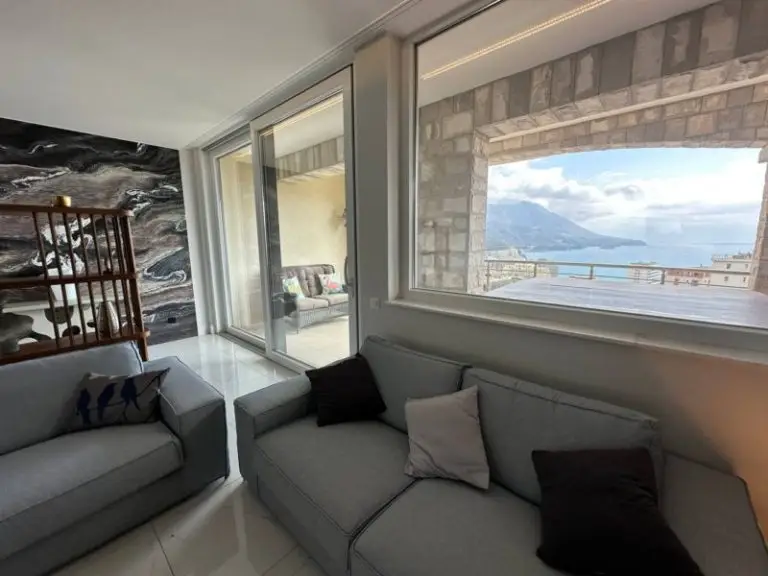 Gray sofas in living room with sea view through large window