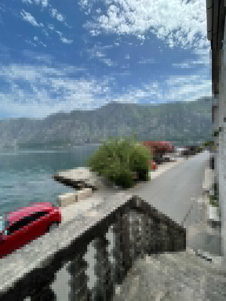 Waterfront road beside sea, mountains, and blue sky