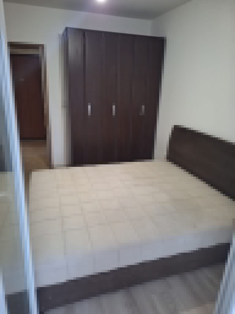 Bedroom with bed, dark wardrobe, and doorway
