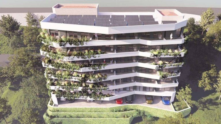 Modern white apartment building with wavy balconies and rooftop solar panels
