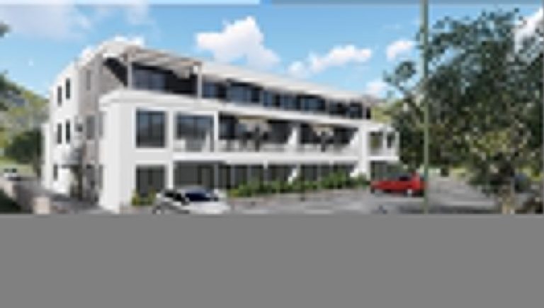 Modern white apartment building with balconies and parked cars