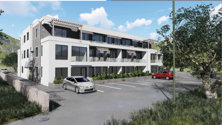 Modern white apartment building with parked cars