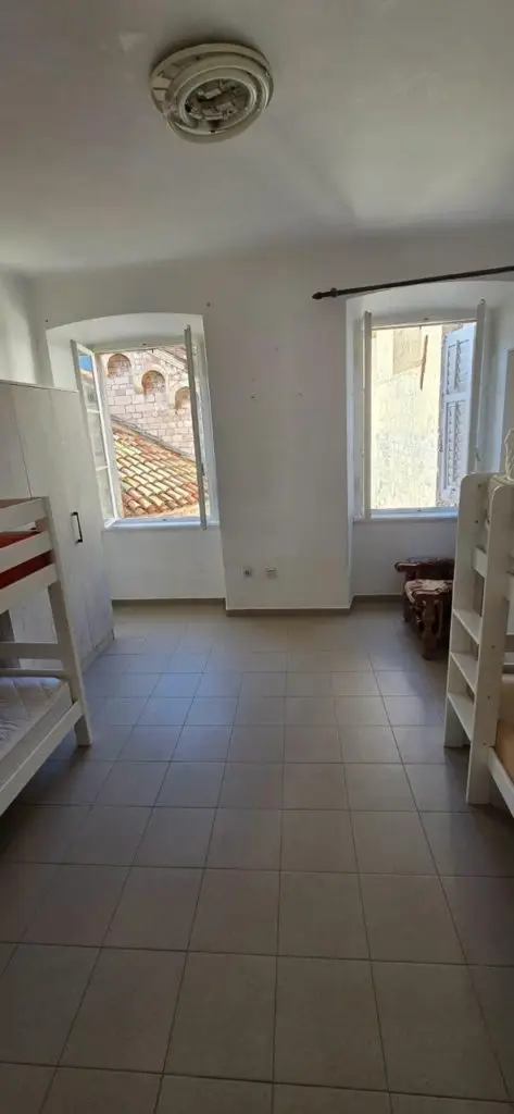 White tiled bedroom with bunk beds and two open windows