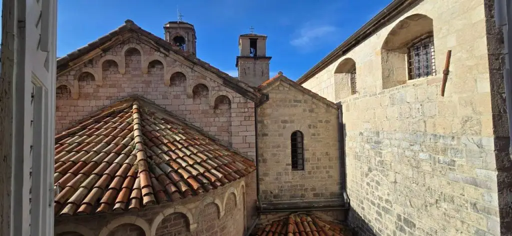 Stone courtyard with tiled roofs and church towers